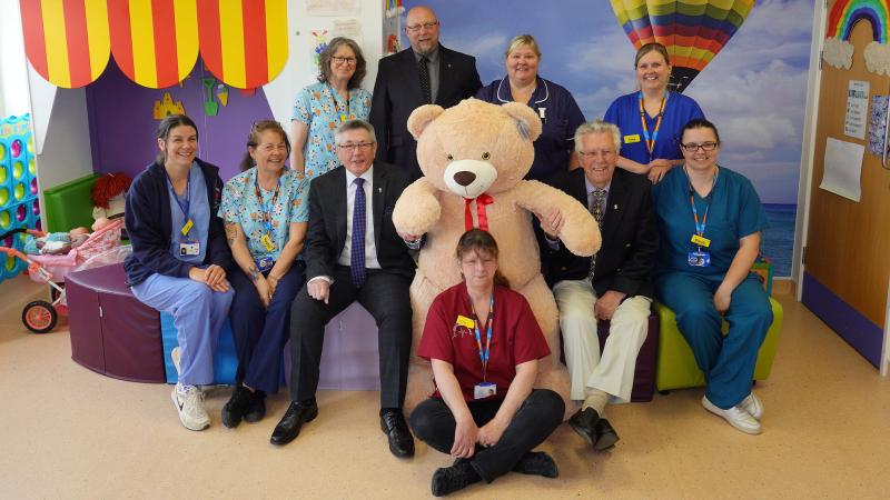 jpg ‘Charlie the Bear’ taking centre stage in the Caroline Thorpe Children's ward, on his left W Bro Charlie Yelland (Asst Provincial Grand Master, Devonshire Freemasons) on his right W Bro Keith Bower (TLC Devonshire), behind W Bro Adam Jeffery (Keeper of Bears in North Devon). Seated in front on floor, Pat Davies ( Adv Clinical Physiologist and NHS Bear administrator). jpg ‘Charlie the Bear’ taking centre stage in the Caroline Thorpe Children's ward, on his left W Bro Charlie Yelland (Asst Provincial Grand Master, Devonshire Freemasons) on his right W Bro Keith Bower (TLC Devonshire), behind W Bro Adam Jeffery (Keeper of Bears in North Devon). Seated in front on floor, Pat Davies ( Adv Clinical Physiologist and NHS Bear administrator).